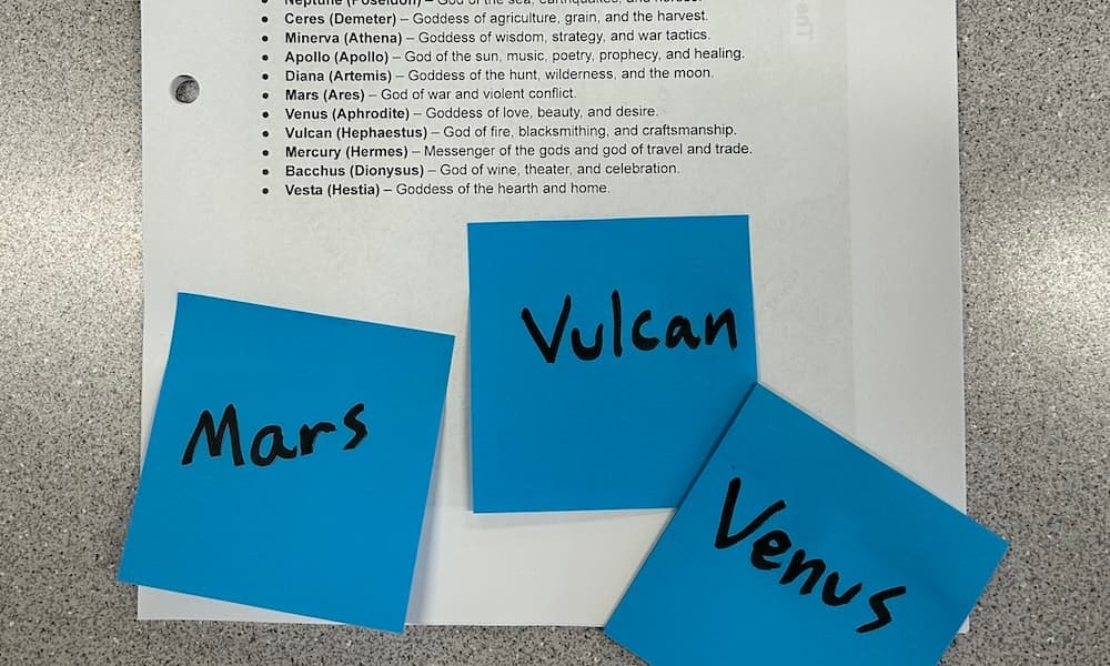 A sheet of Latin vocabulary to learn with sticky notes on top. The sticky notes have the names of Roman deities on them.